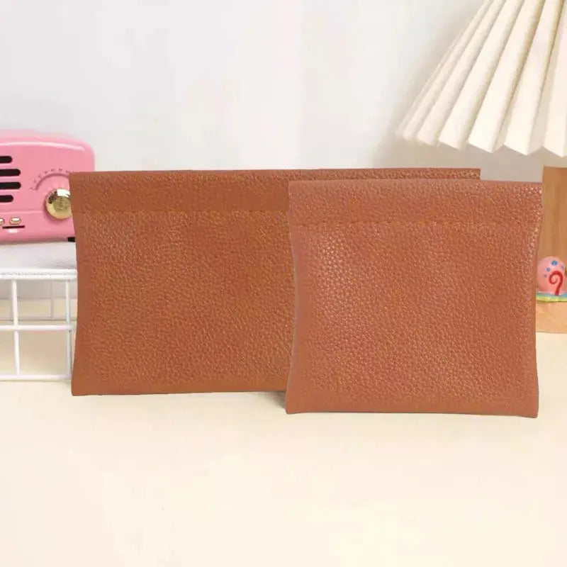 Two brown textured artificial leather wallets: a long wallet and a passport/ID holder, self-closing