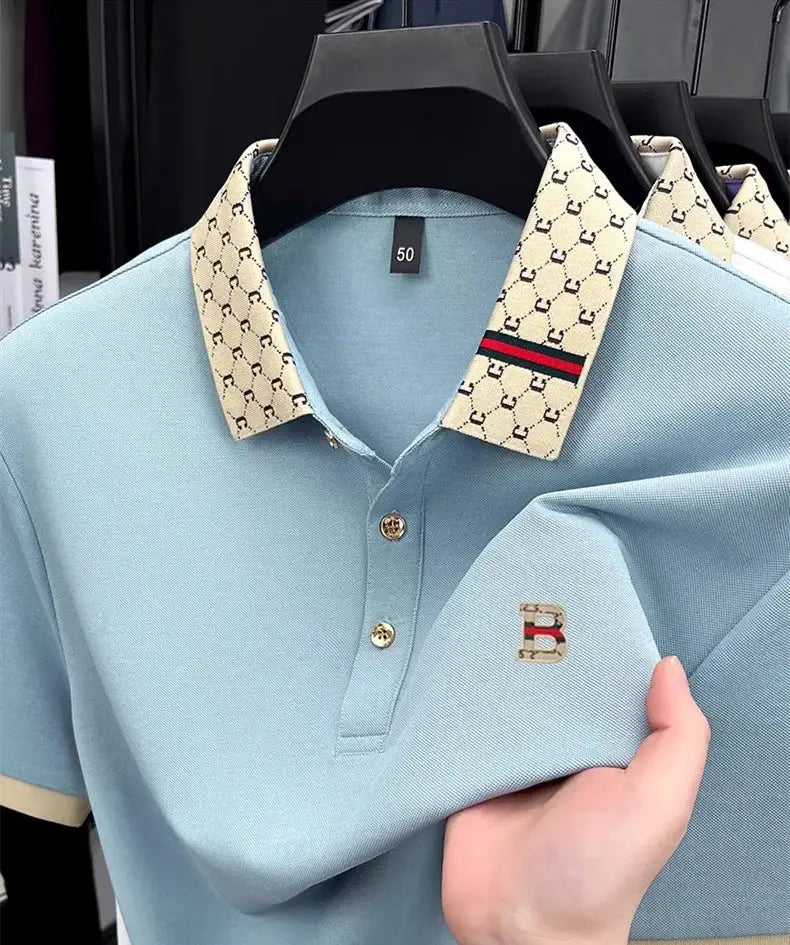 Two men's polo shirts in light blue with beige patterned collars and B logo embroidery; breathable, short sleeves.