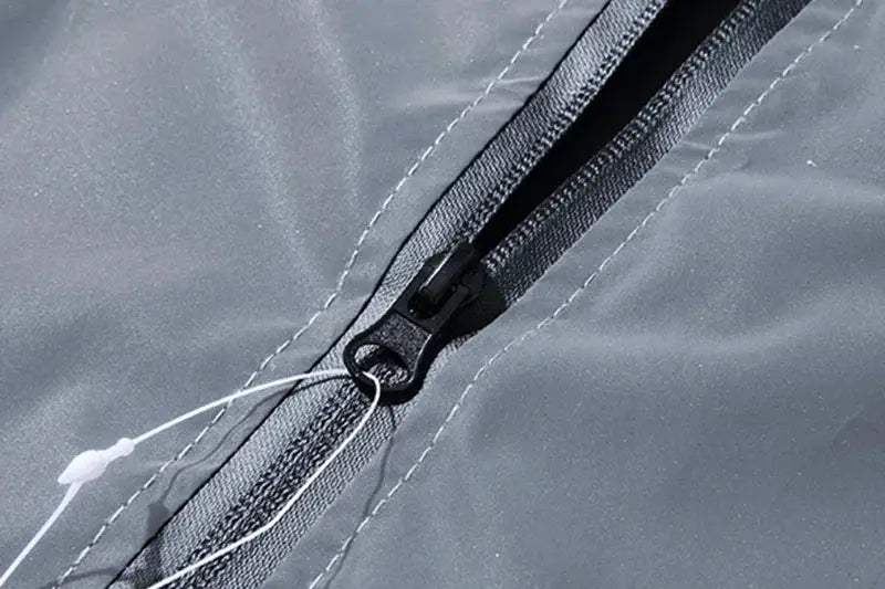 Jacket, grey reflective polyester with black zipper and white drawstring.