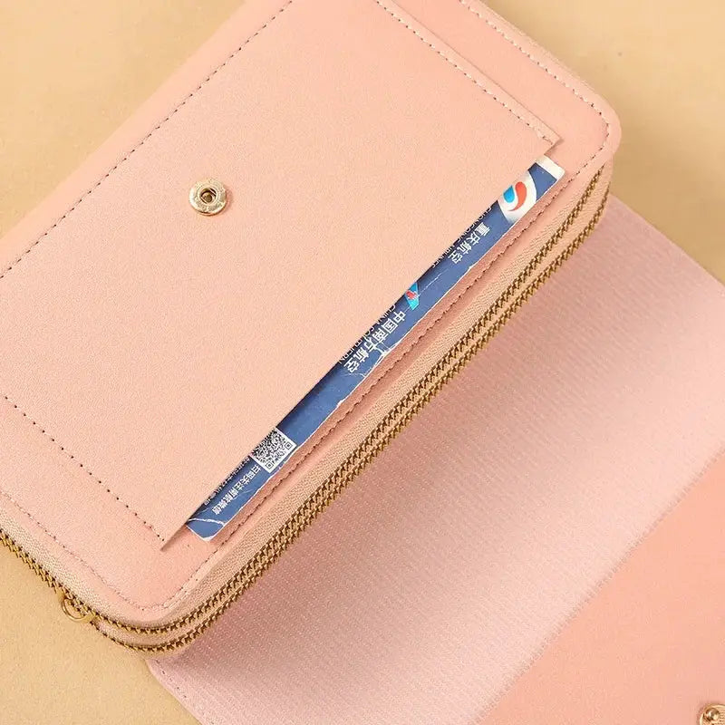Women's mid-size pink wallet bag with gold zippers and coin pocket; convertible shoulder clutch.