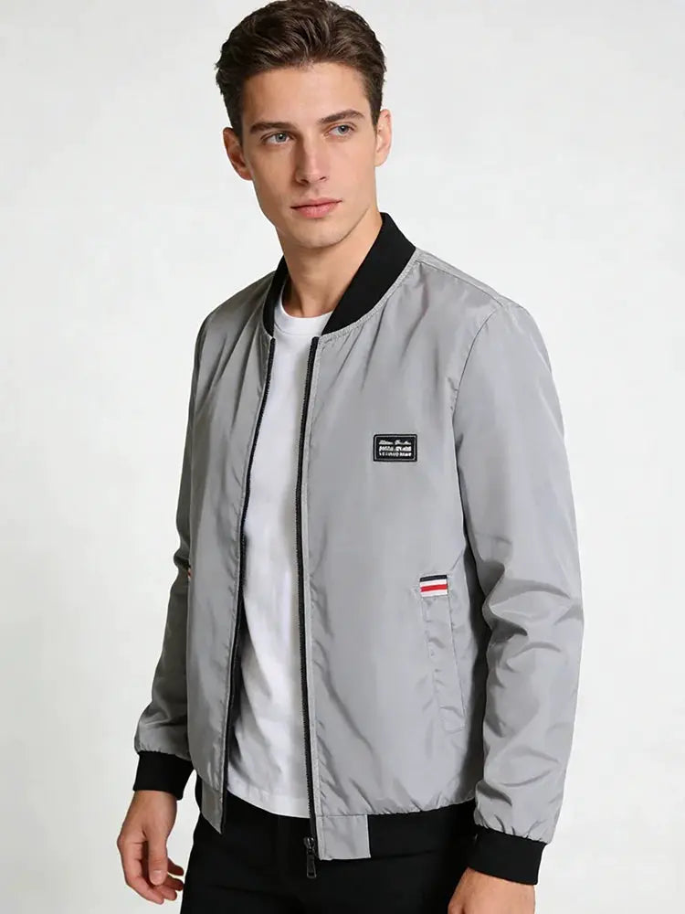 Simples Market men's gray lightweight windbreaker with zip front, black ribbed collar and cuffs, chest logo patch.