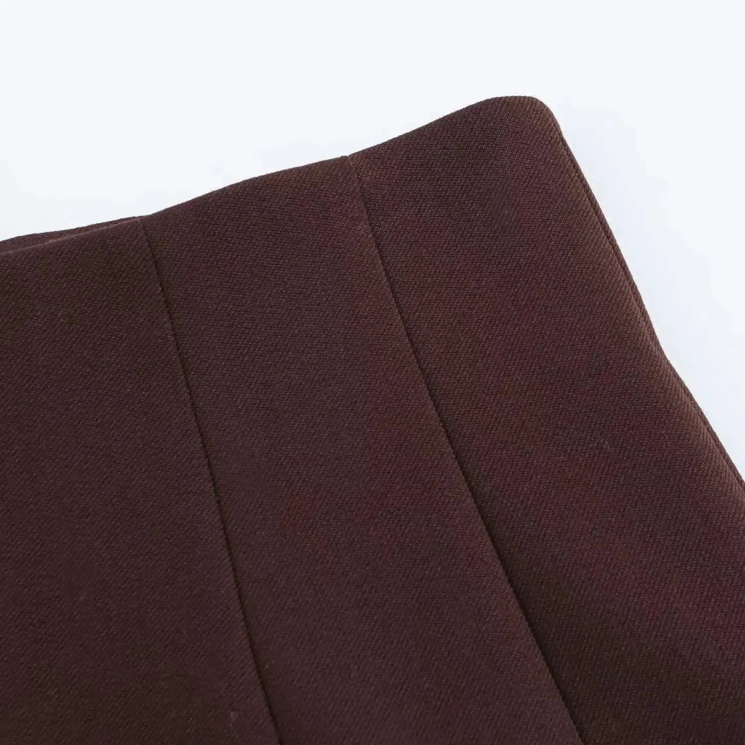 Brown textured blazer fabric close-up with visible seams
