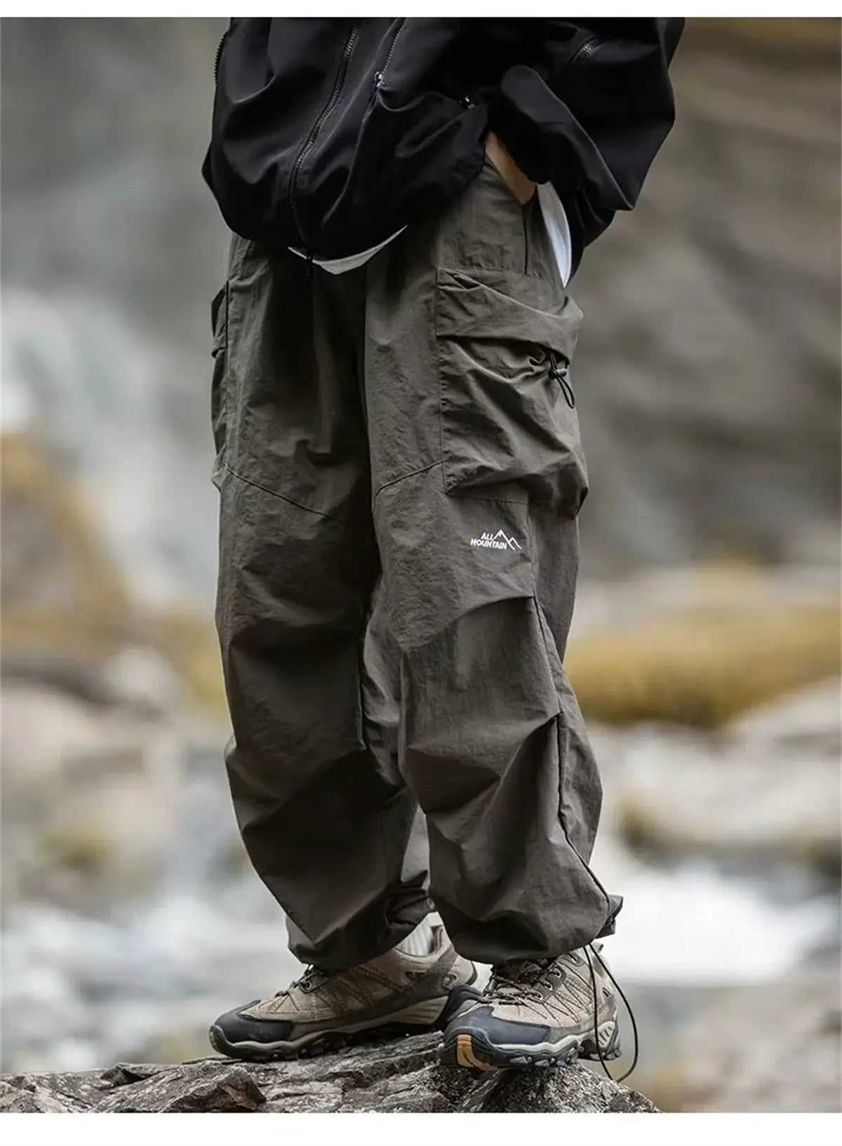Men's waterproof mountaineering cargo pants with All Mountain logo; dark gray, rugged cargo pockets