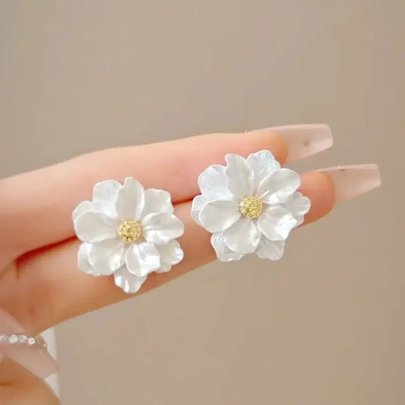 White enamel flower earrings with gold centers by Simples Market