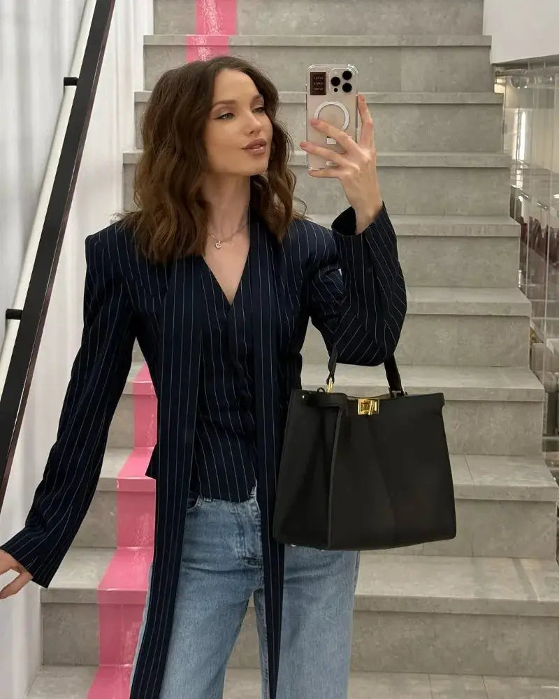 Trendix Elegant blazer 2-piece set, navy pinstripe with V-neck; model styled with jeans and black handbag.