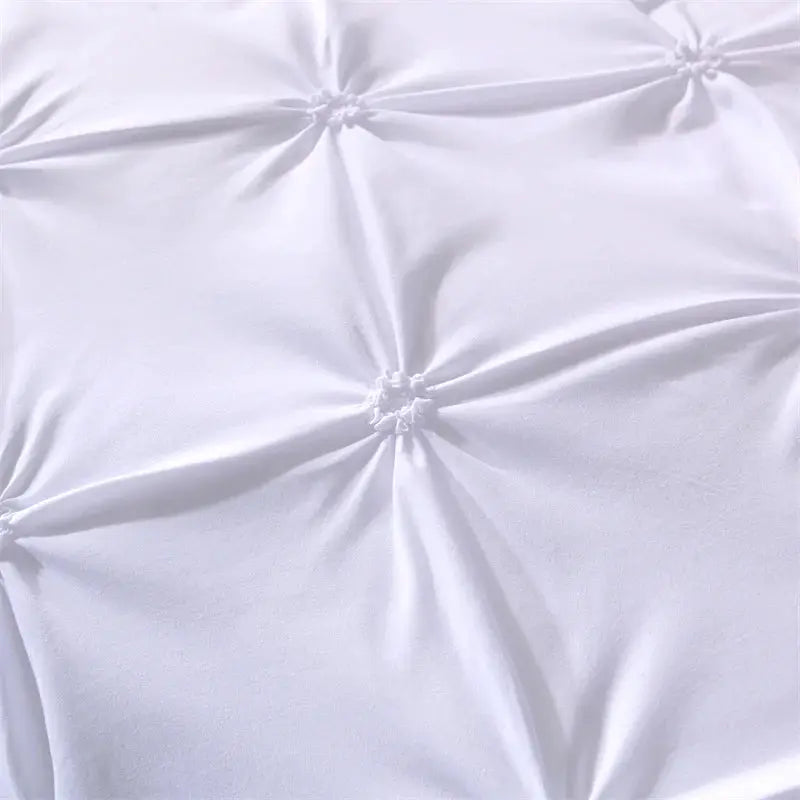 Queen duvet cover and pillowcases from Simples Market in white; close-up of smooth fabric with tufted detailing