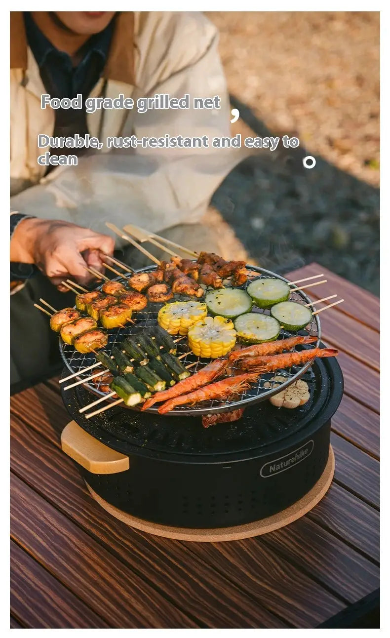 Naturehike tabletop barbecue stove; black portable grill with skewers of meat and vegetables.