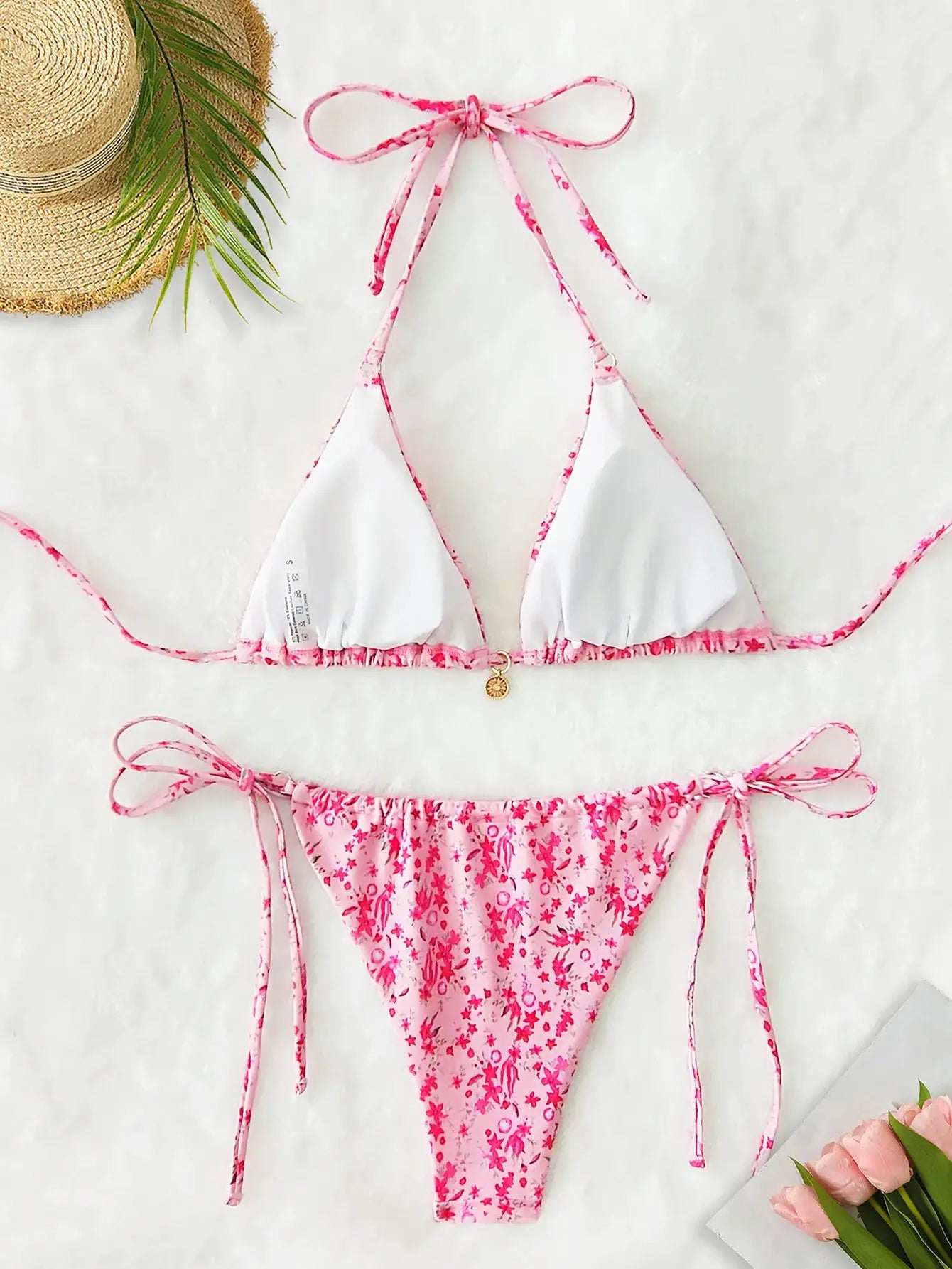 Women's bikini set in pink floral print with white triangle cups and adjustable tie-side bottoms