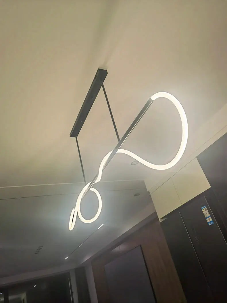 Nordic LED pendant light by Simples Market with a white looping ring design and black ceiling mount