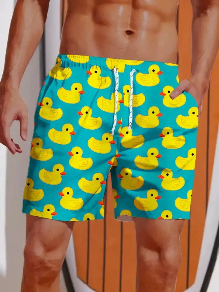 Men's turquoise swim shorts with bright yellow duck print, elastic waistband with white drawstrings, casual beachwear