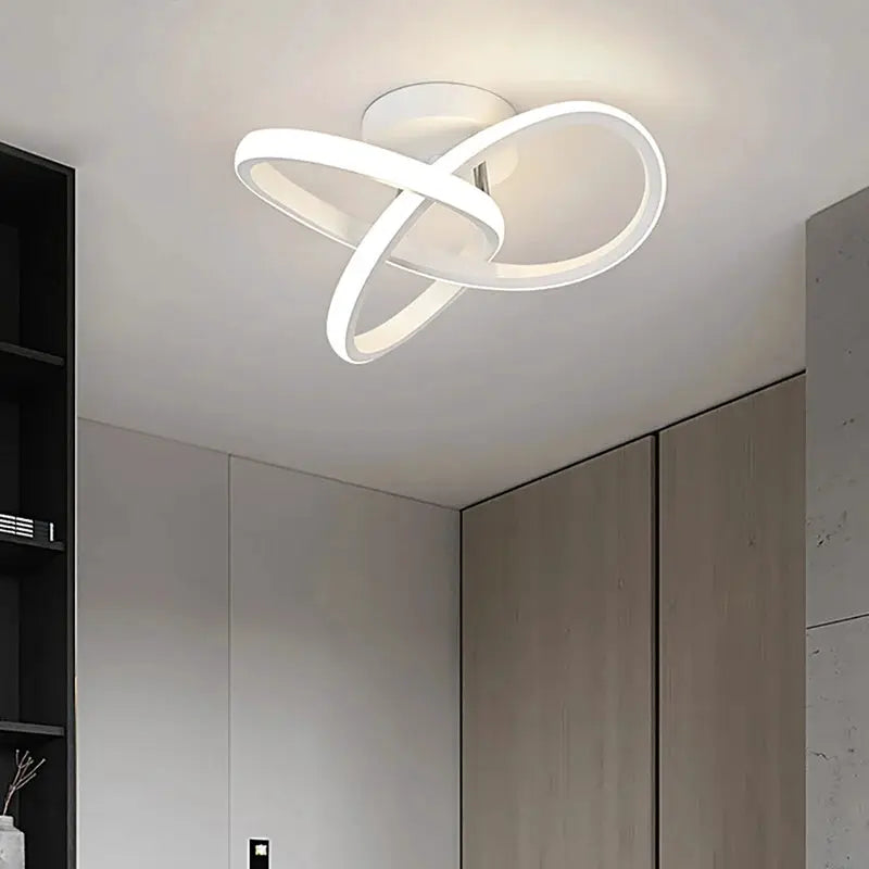 Modern LED ceiling light by Simples Market with white looping rings, surface-mounted.