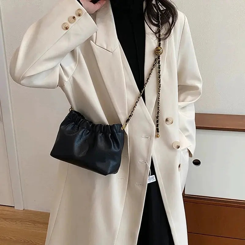 Women's black chain-strap crossbody bag with gathered top.