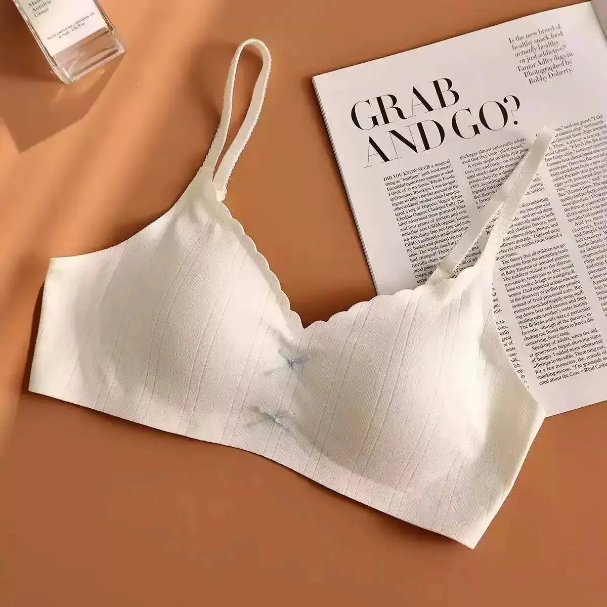 Women's white gathered sports bra with thin straps and scalloped edge, breathable fabric