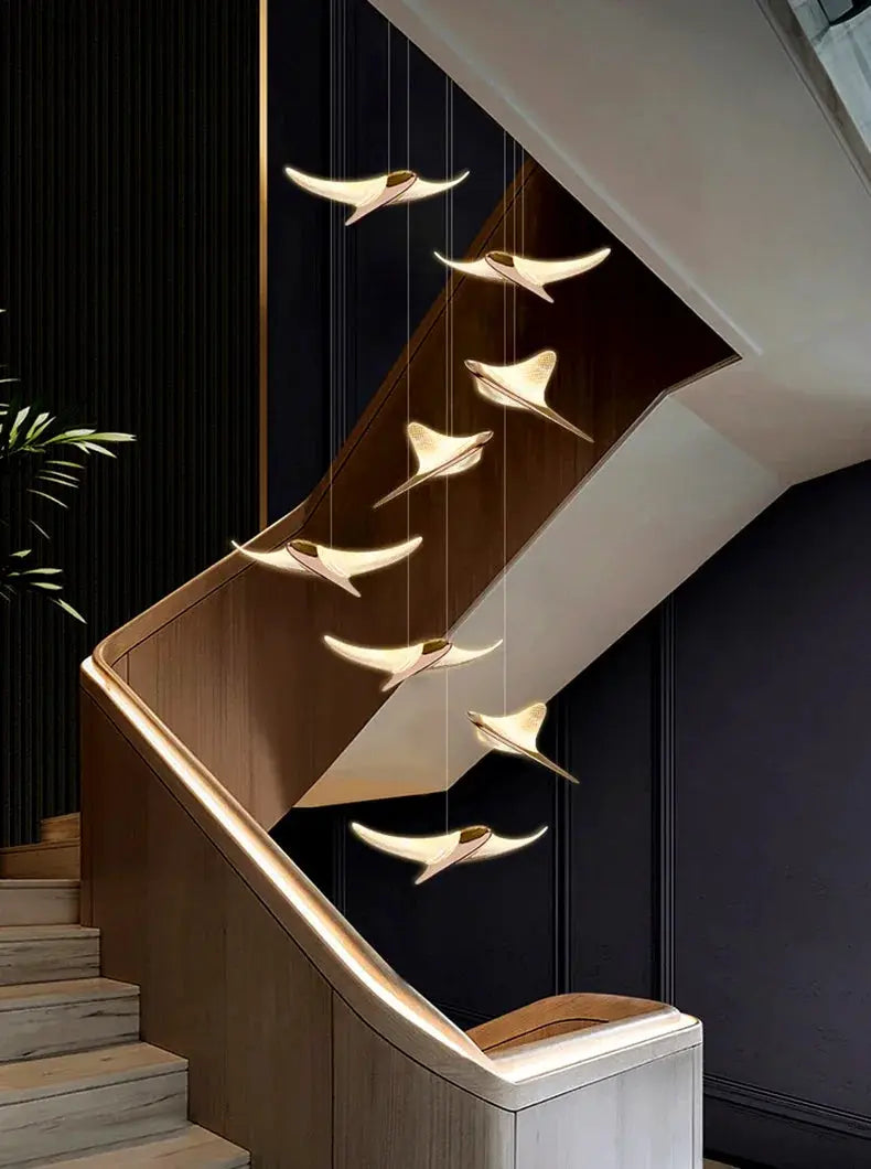 Seagull staircase pendant lamp by Simples Market, gold finish with cascading bird lights along stairs.