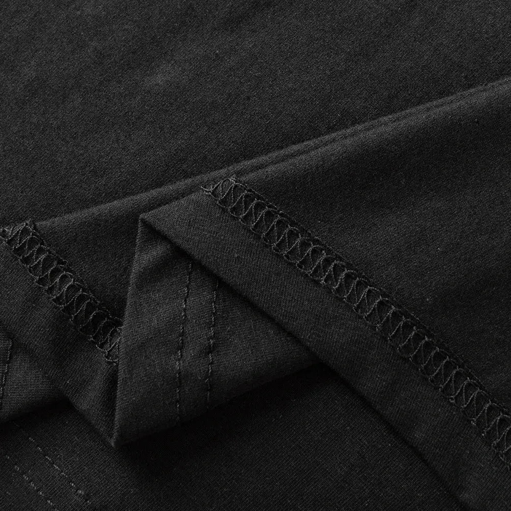 Men's black cotton T-shirt fabric close-up with visible stitching and hem seams