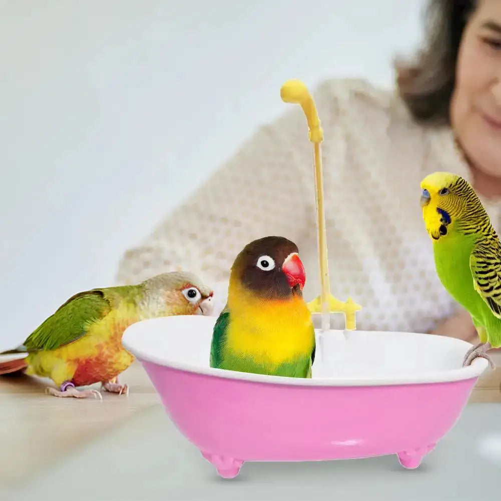 Parrot bath tub with pink plastic basin and yellow shower faucet; three parrots nearby