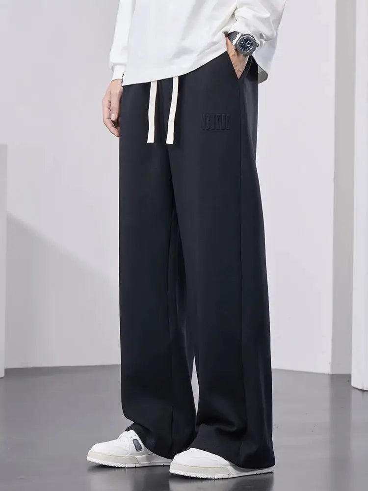 Men's black cotton track pants with a wide leg and drawstring waist