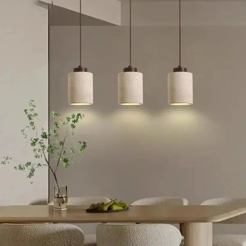 Led pendant lamp set by Simples Market, three cream concrete-texture shades over a wooden dining table.