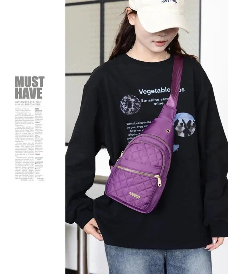 Chest bag by Simples Market, purple quilted crossbody with gold zippers.