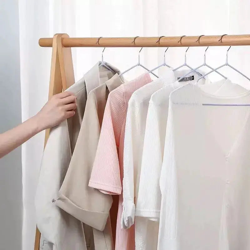 Multi Functional Anti Slip No Trace Metal Hanger on wooden wardrobe rack with light-colored clothes