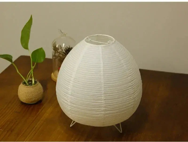 Japanese lantern LED table lamp with white rice paper shade, spherical on small metal tripod feet.