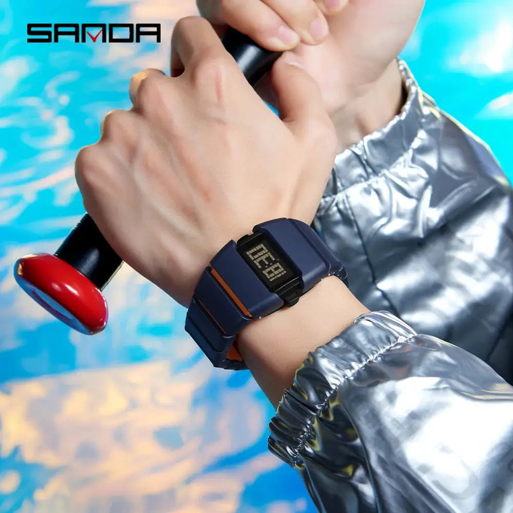 SANDA digital watch on navy blue strap with orange accents, worn on the wrist.