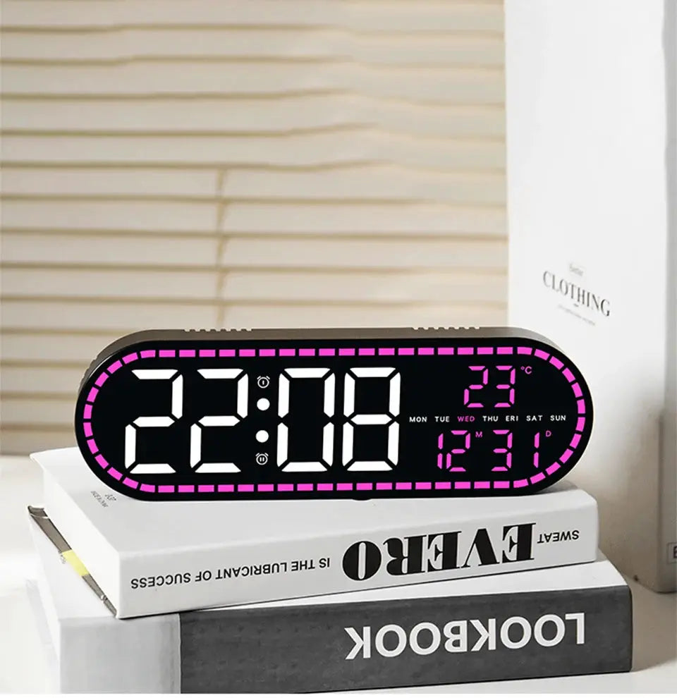 Simples Market digital LED wall clock with pink dotted frame showing 22:08, date, weekday and temp; on stacked books