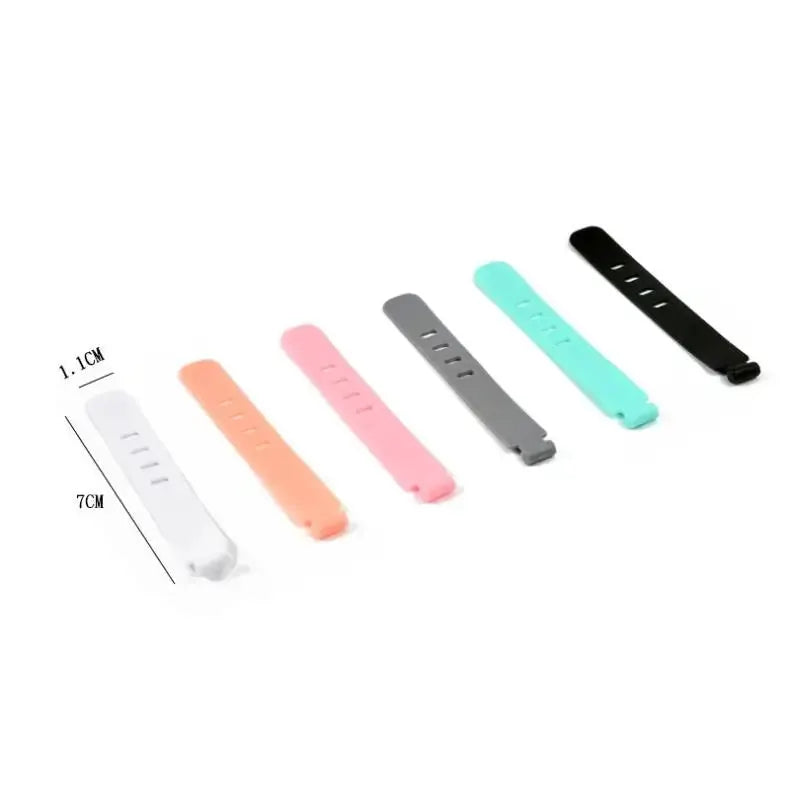 Six silicone cable organizer ties in white, orange, pink, gray, teal, and black