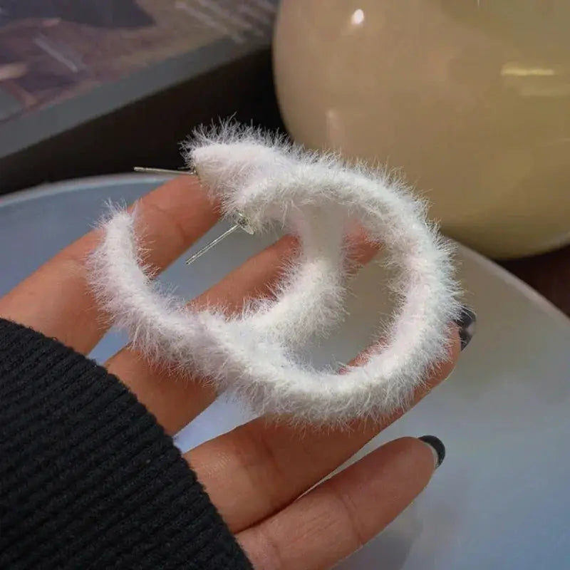 Pair of white fluffy hoop earrings made of faux fur, circular dangle hoops