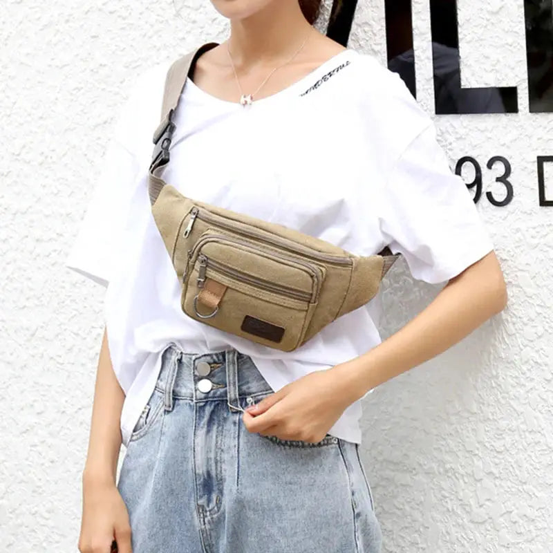 Chest bag by Simples Market, camel canvas waist bag with multiple zip pockets worn crossbody.