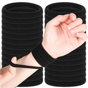 Kids black elastic hair bands; multiple thin ties stacked, with a hand wearing one.