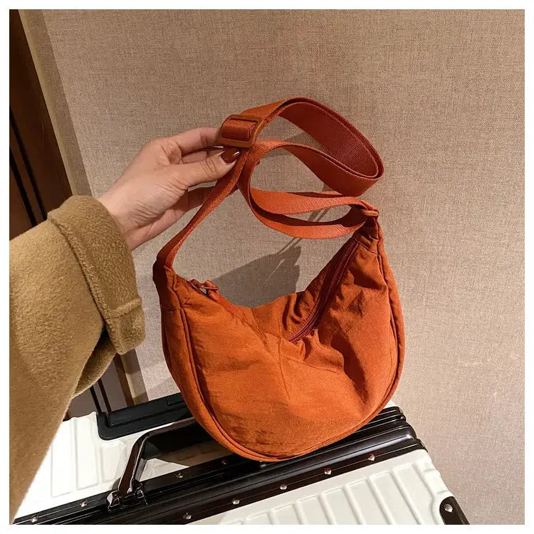 Casual nylon hobo crossbody bag in orange with adjustable strap and top zipper