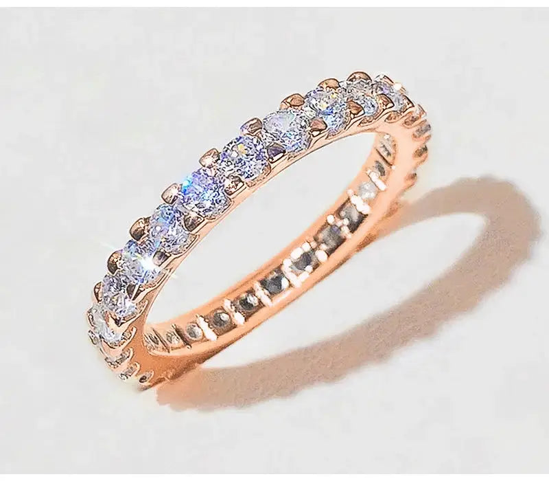 Rose gold-tone S925 sterling silver ring with pave cubic zirconia stones along the band