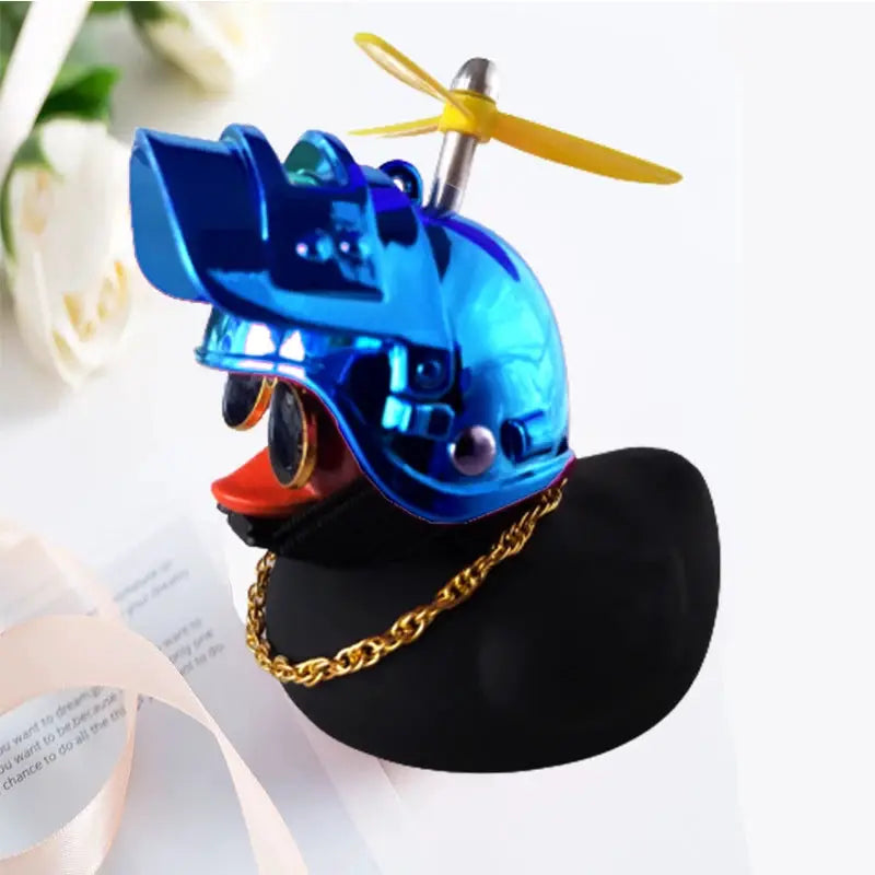 Rubber duck car accessory with blue metallic helmet and yellow propeller on a black cap, Simples Market