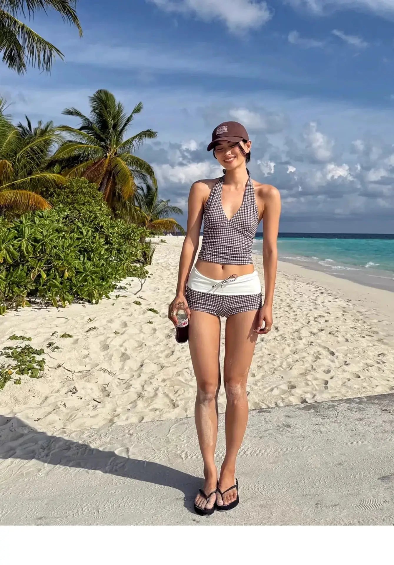 Simples Market two-piece bikini set; black-and-white checkered halter top with high-waisted bottoms on the beach