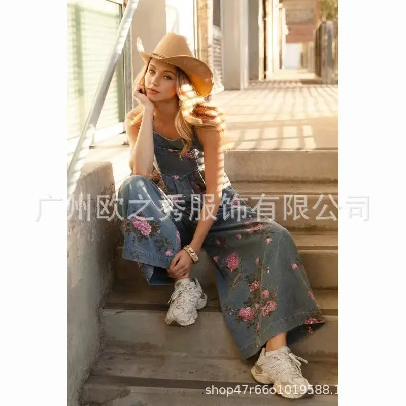 Denim floral print sleeveless jumpsuit by Simples Market in blue denim with pockets and wide legs.