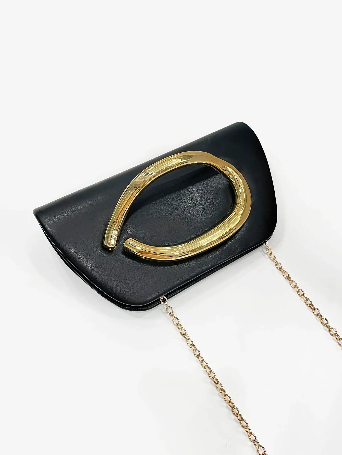 Box clutch in black leather with a large gold-tone buckle and chain strap