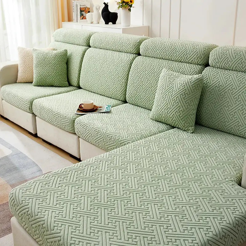 Sectional sofa slipcover in sage green jacquard geometric pattern; stretch, adjustable, protects furniture.
