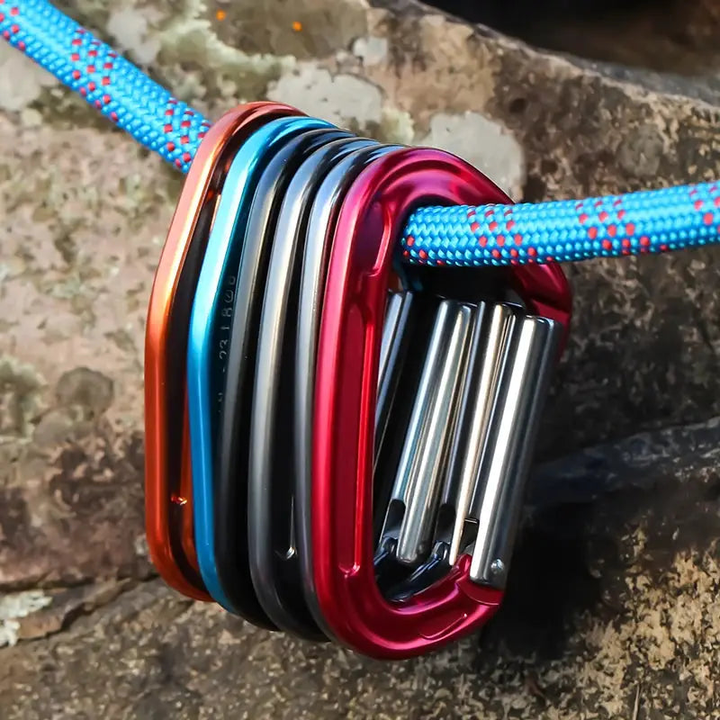 Aluminum climbing carabiner set in assorted anodized colors threaded on a blue rope