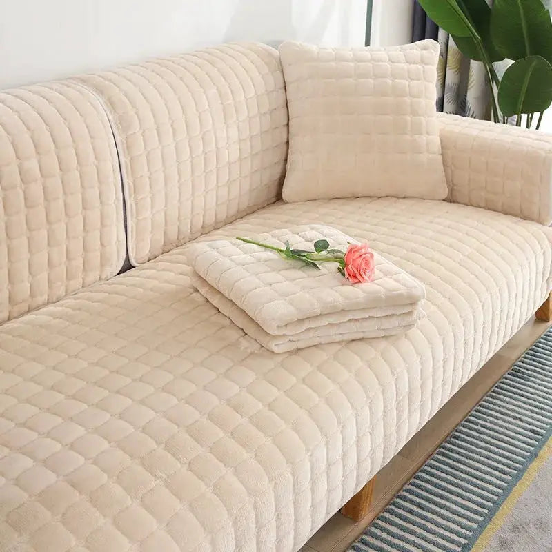 Velvet beige plaid sofa cover by Simples Market; plush quilted, non-slip with folded towels on top.
