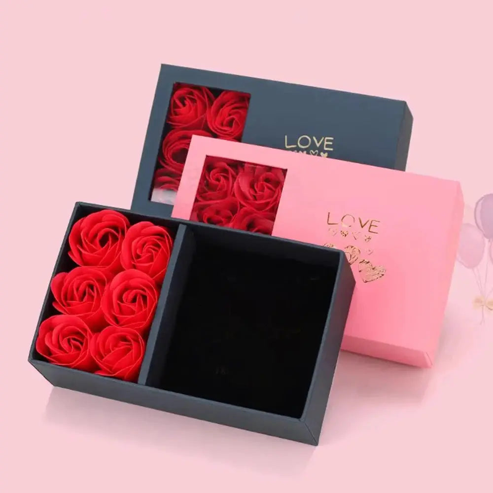 Jewelry box with red immortality roses in a navy blue presentation box, pink gift box backdrop