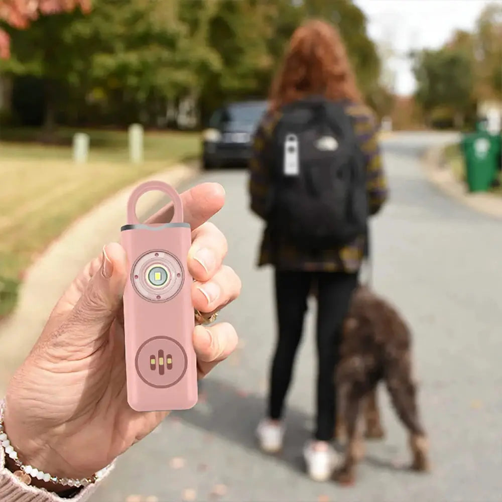 Pink 130dB rechargeable personal alarm keychain with LED flash by Simples Market