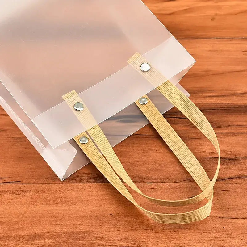 Frosted tote bag with beige strap handles and metal rivets, eco-friendly gift bag.