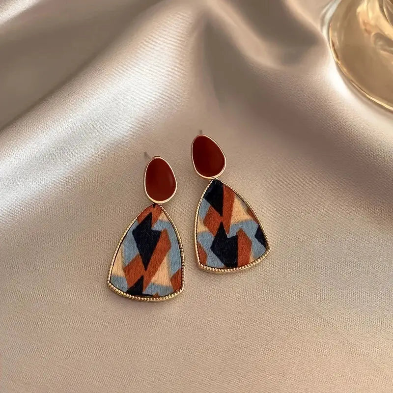 Pair of earrings: wine-red teardrop studs with gold-tone trim and multicolor geometric triangle drops