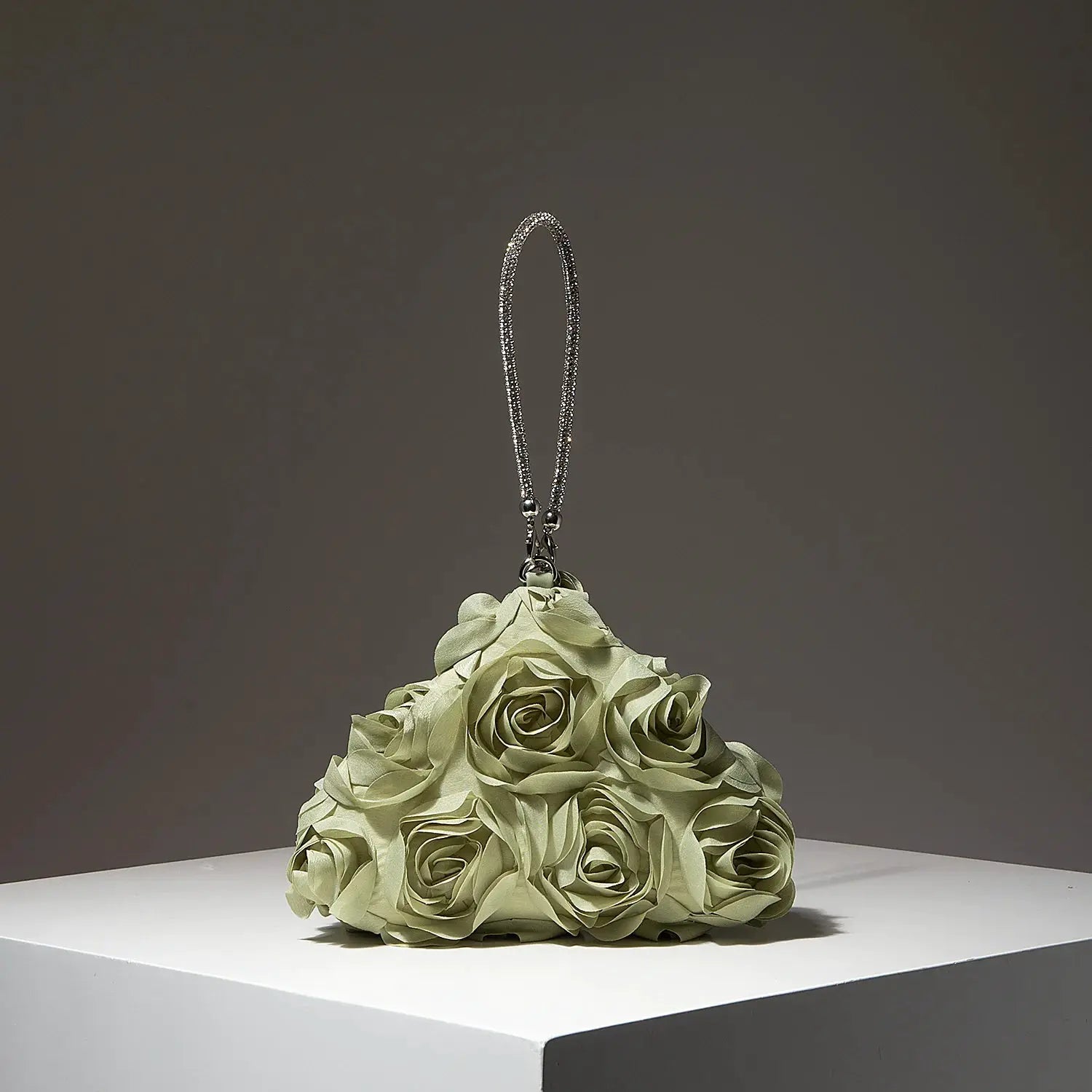 Mini purse with silver rhinestone strap atop a pale green rose bouquet