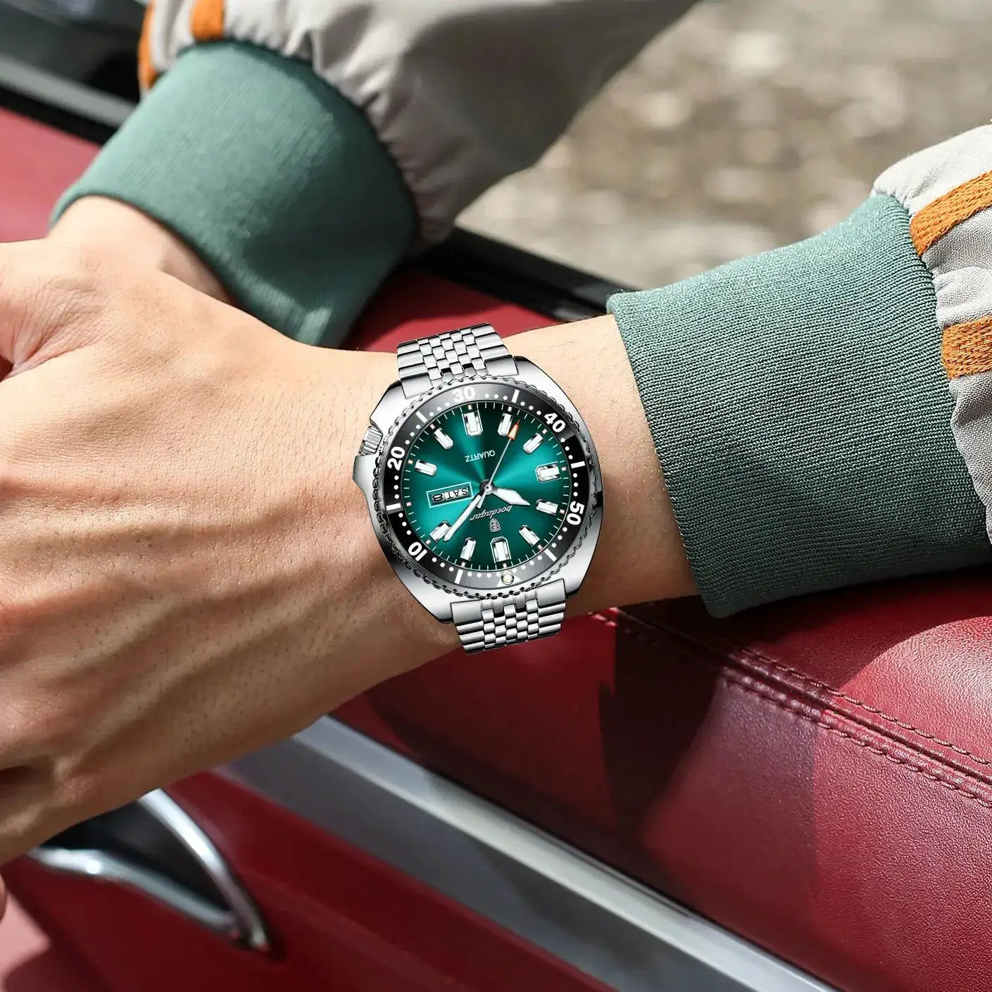 POEDAGAR men's stainless steel watch with green dial, date window, and luminous markers on a metal bracelet