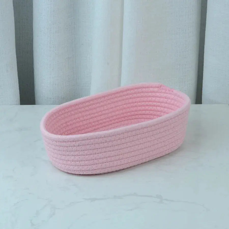 Pink oval woven storage basket; desktop organizer for cosmetics, toys and office supplies.
