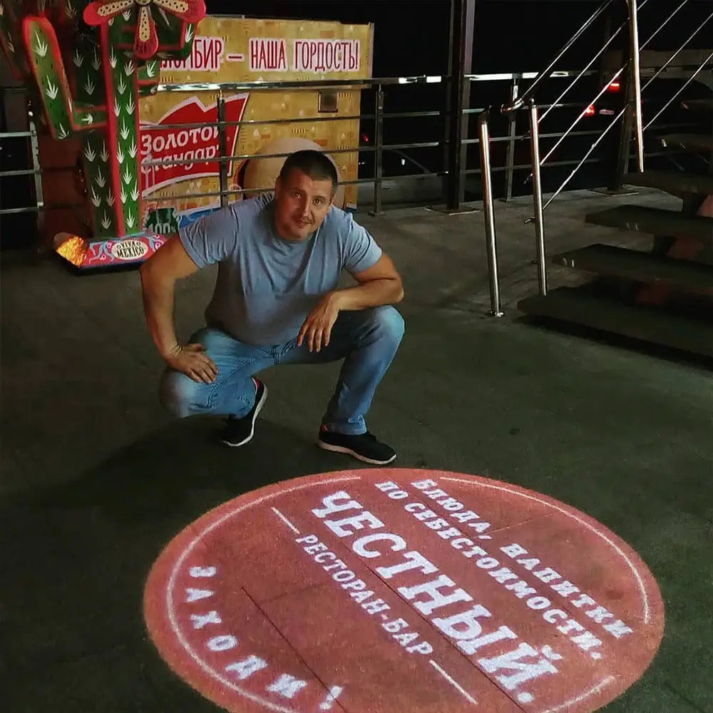 Advertising gobo projector outdoor LED light projecting a custom red logo on the floor
