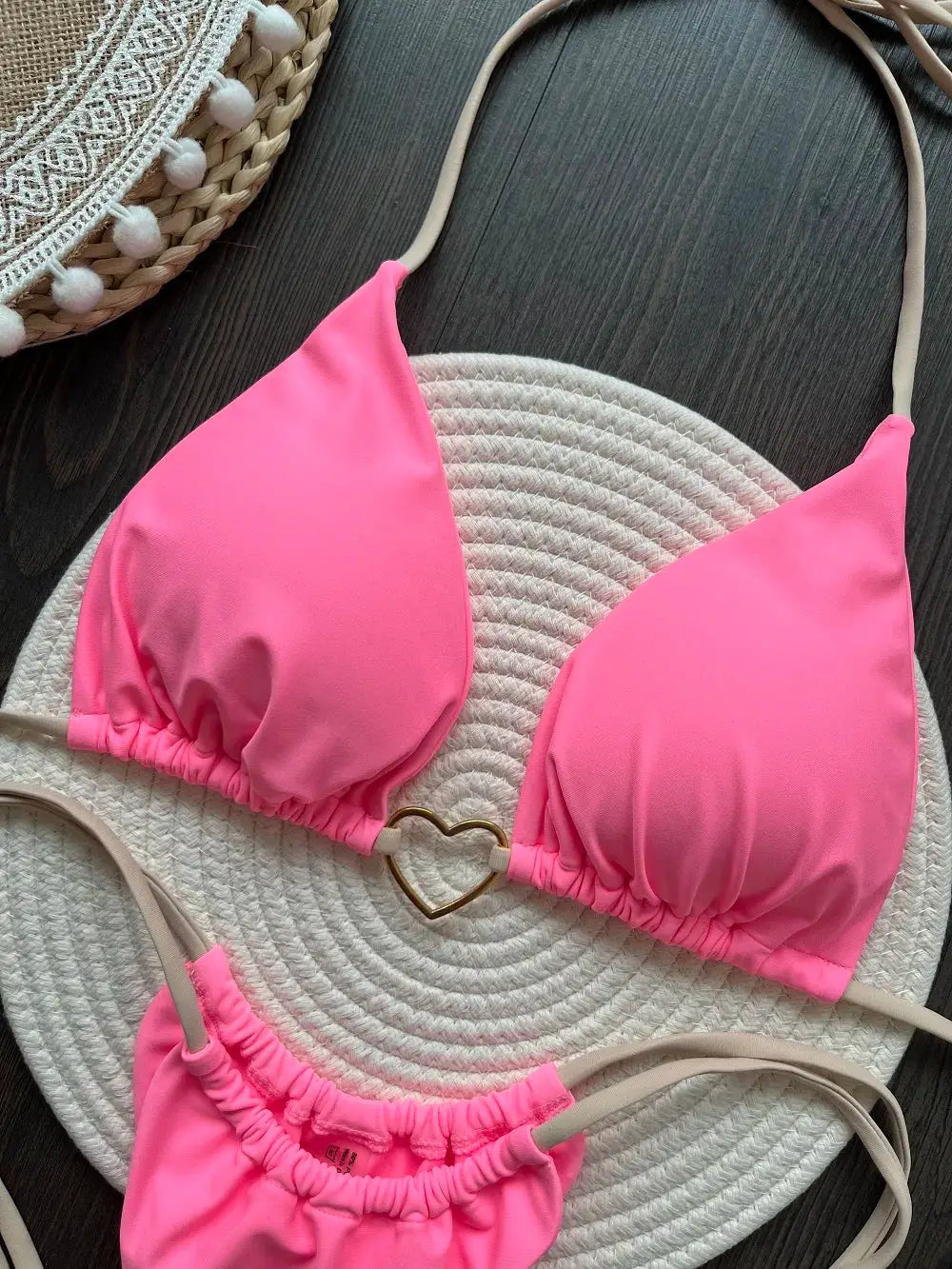 Pink two-piece halter bikini with triangle cups and gold heart centerpiece, ruched bottoms