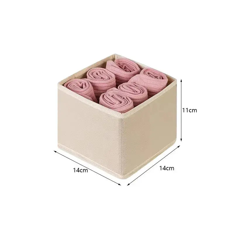 Foldable storage box by Simples Market; beige fabric cube with 9 pink rolled socks, 14×14×11 cm.